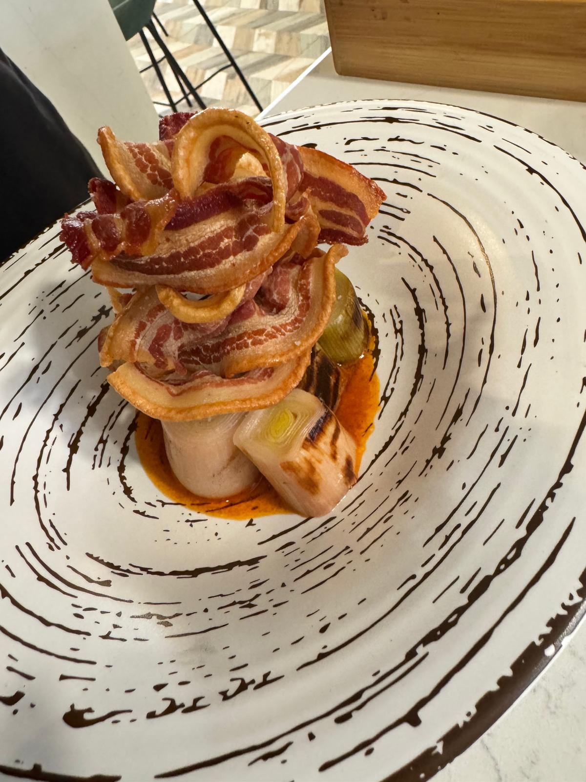 Puerro-confitado-con-carpaccio-de-torrezno-y-salsa-romesco